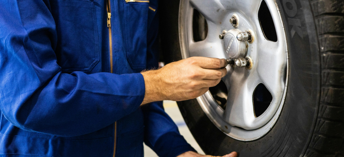 auto technician replacing car tire in repair shop